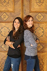 Das Bild zeigt zwei Studentinnen der BA Logopädie. Sie stehen mit überkreuzten Armen Schulter an Schulter vor einer braunen Tür.
