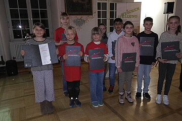 Eine Gruppe Kinder halten Urkunden mit der Aufschrift Weichenstellung in ihren Händen.