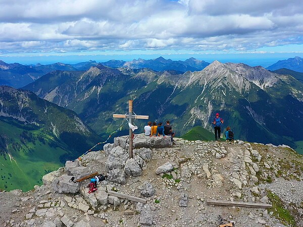 Panoramablick auf ein Bergkreuz in den Alpen