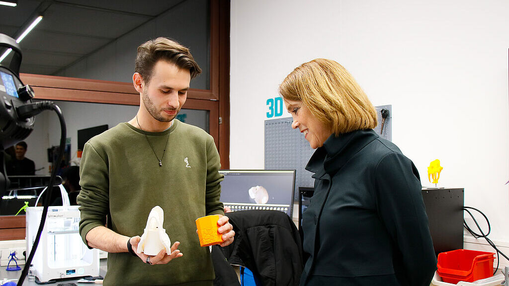 Ein Student zeigt der Ministerin 3D-Objekte, die er mit einem 3D-Drucker in der Werkbox des CoLiLabs der PH Weingarten erstellt hat. In dem pädagogischen Makerspace können Studierende digitale und Medien-Projekte absolvieren, um digitale Kompetenzen erwerben, mit denen sie später ihren Unterricht bereichern können. Ministerin_Olschowski_im_CoLiLab